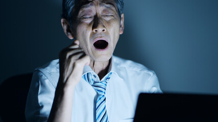 残業する高齢ビジネスマンイメージ　眠気