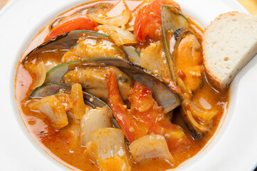 Mussels and red peppers in an Asian soup at a Korean restaurant.