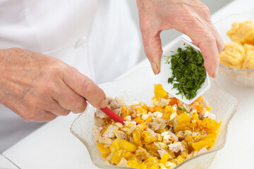 Senior woman preparing the filling for a traditional dish from el Valle del Cauca in Colombia called empanada