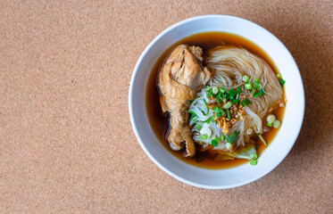 Thai Food, Thin Chicken Noodle Soup With vegetables and chicken drumsticks in white bowls, On top view