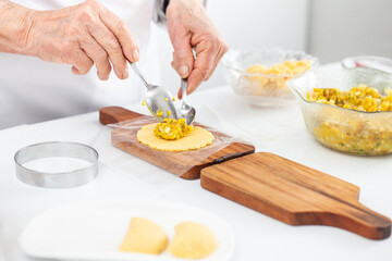 Senior woman filling an empanada a traditional dish from el Valle del Cauca in Colombia