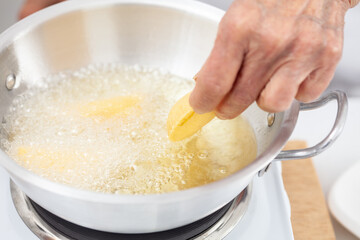 Senior woman frying a traditional dish from el Valle del Cauca in Colombia called empanada
