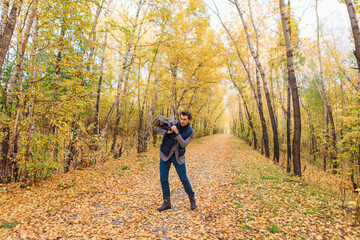 Fototapeta premium Tall handsome man with a bag in the autumn alley