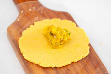 Senior woman filling an empanada a traditional dish from el Valle del Cauca in Colombia