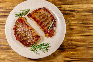 Grilled pork steaks with rosemary on wooden table. Top view