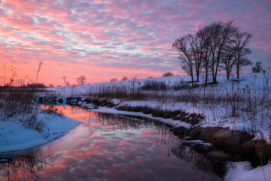 A colorful sunset sky over a quiet winter landscape.