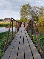 Obraz premium Old pedestrian bridge over the river