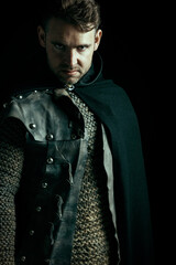 A male historical or urban fantasy character wearing a leather jerkin, mail vest and cloak against...