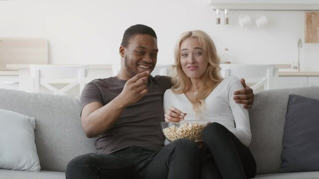 Couple Watching TV Together Eating Popcorn Having Fun At Home