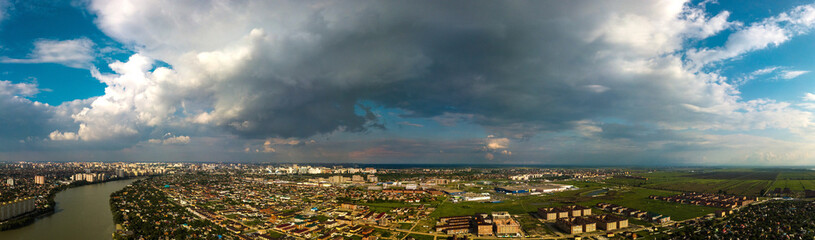 thundercloud over the river and low-rise area in the suburbs of Krasnodar on a sunny spring day
