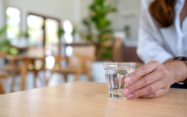 Closeup image of a woman holding a glass of water to drink