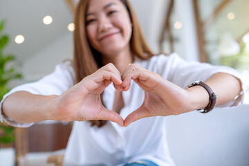 A beautiful asian woman making heart hand sign with feeling happy