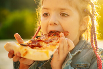 Kids favorite food. Tasty pizza. Child eating pizza. Fastfood. Italian junkfood. Little girl lunch outdoor.