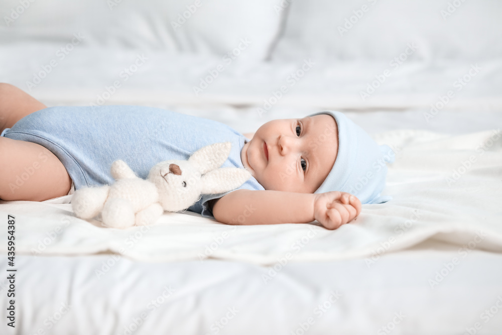 Wall mural Cute little baby lying on bed at home