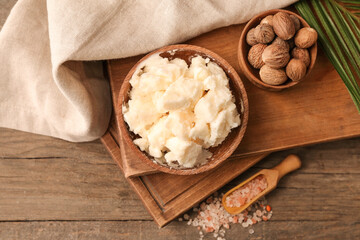 Bowl with shea butter, nuts and sea salt on wooden background