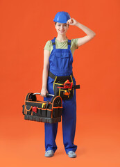 Beautiful female electrician with tools on color background