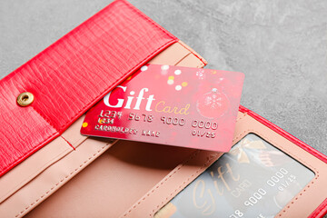 Wallet with gift cards on grunge background, closeup