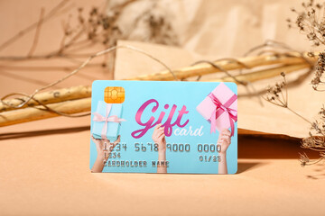 Gift card and floral decor on color background