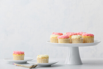 Tasty cupcakes on light background