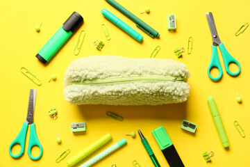 Pencil case and stationery on color background