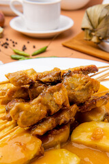 Pork Satay or Sate Babi.

Pork Satay served with a spicy served with Padang sauce and slices of lontong or ketupat (rice cakes), garnished with a sprinkle of bawang goreng (crisp fried shallot)