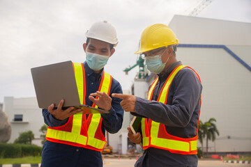 Two Engineer working computer technology on site construction, Two Engineer wear mask protect covid19