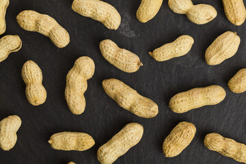 Peanuts on a black stone background.