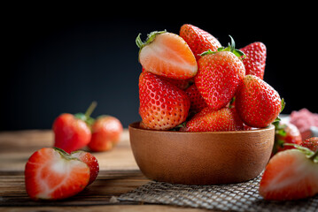 Fresh strawberries in wooden bowl.