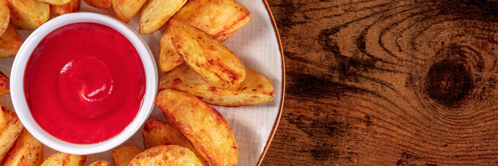 Tomato sauce and baked potato wedges close-up, a panoramic banner