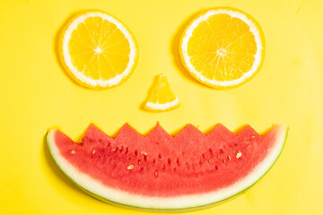 Orange slices and watermelon pieces arranged in the shape of a human face