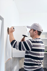 Handyman worker making hole for airduct ventilation in the kitchen.