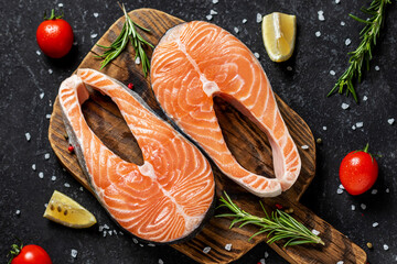 Salmon with tomatoes, peppers, lemon, tomatoes and dill on the rustic board