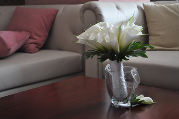 bridal bouquet of white calla lilies side view on a light interior background closeup. Selective focus