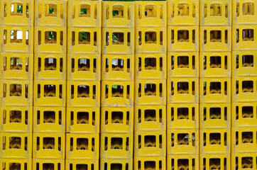 Yellow Stackable Plastic Bottle Boxes. Lots of empty used glass container crates.