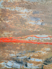 texture of old metal garage wall exposed to weather conditions with rust and bright red paint