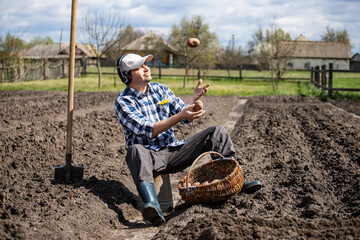 person planting potatoes in the field, juggle potatoes to music