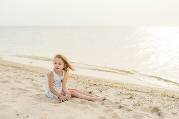 Summer vacation, lovely girl resting on the beach near water