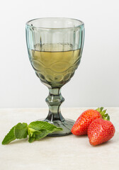 Refreshing drink with strawberries and mint on a neutral backgroud