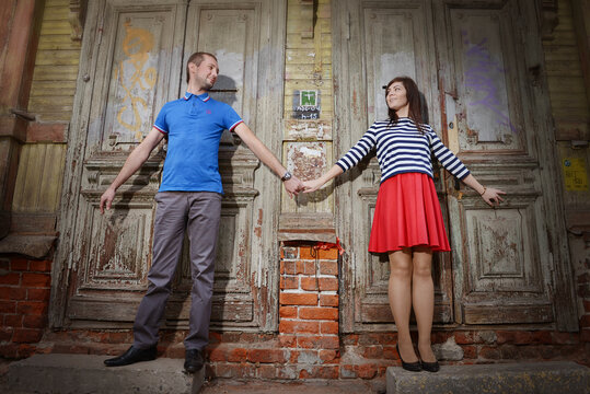 The guy and the girl pressed against the doors of the old house.