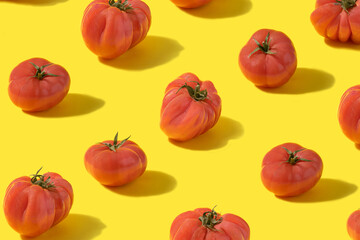 Vibrant pattern made of fresh natural yummy tomato lionheart against illuminate yellow background. Optimistic and abstract concept.