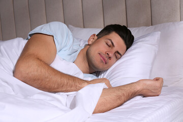Man sleeping in comfortable bed with white linens