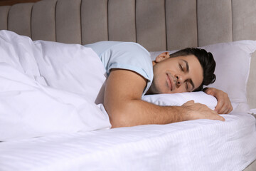 Man sleeping in comfortable bed with white linens