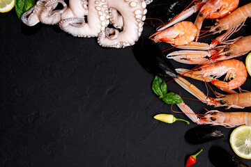Healthy fish and seafood assortment on black background. Top view.  Seafood on black rustic background.