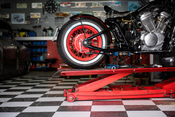 motorcycle raised on the platform to be repaired in a mechanic's shop. mechanics concept. vintage motorcycle