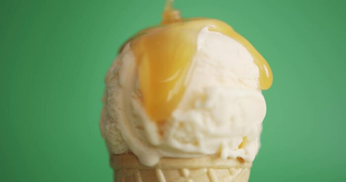 Vanilla Ice Cream Topped with Caramel on green background, Closeup Front view Food concept.