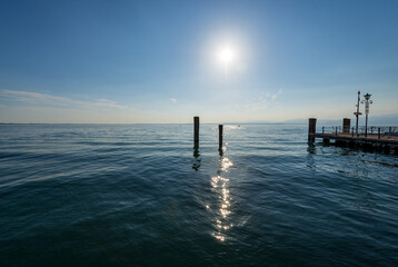Lago di Garda. The Lake Garda view from the port of the small town of Lazise, tourist resort on the coast, Verona province, Italy, southern Europe. In the background the coast of Lombardy.