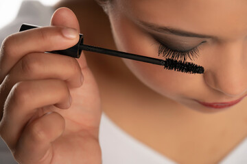Close up of woman applies mascara