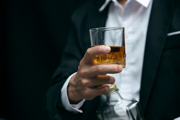 Man wearing a suit whiskey glass of liquor