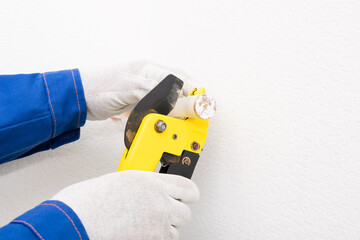 Obraz premium worker cuts off XLPE pipe for plumbing, close-up