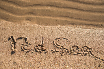 Word Red Sea written in the sand on the beach.  Summer travel concept